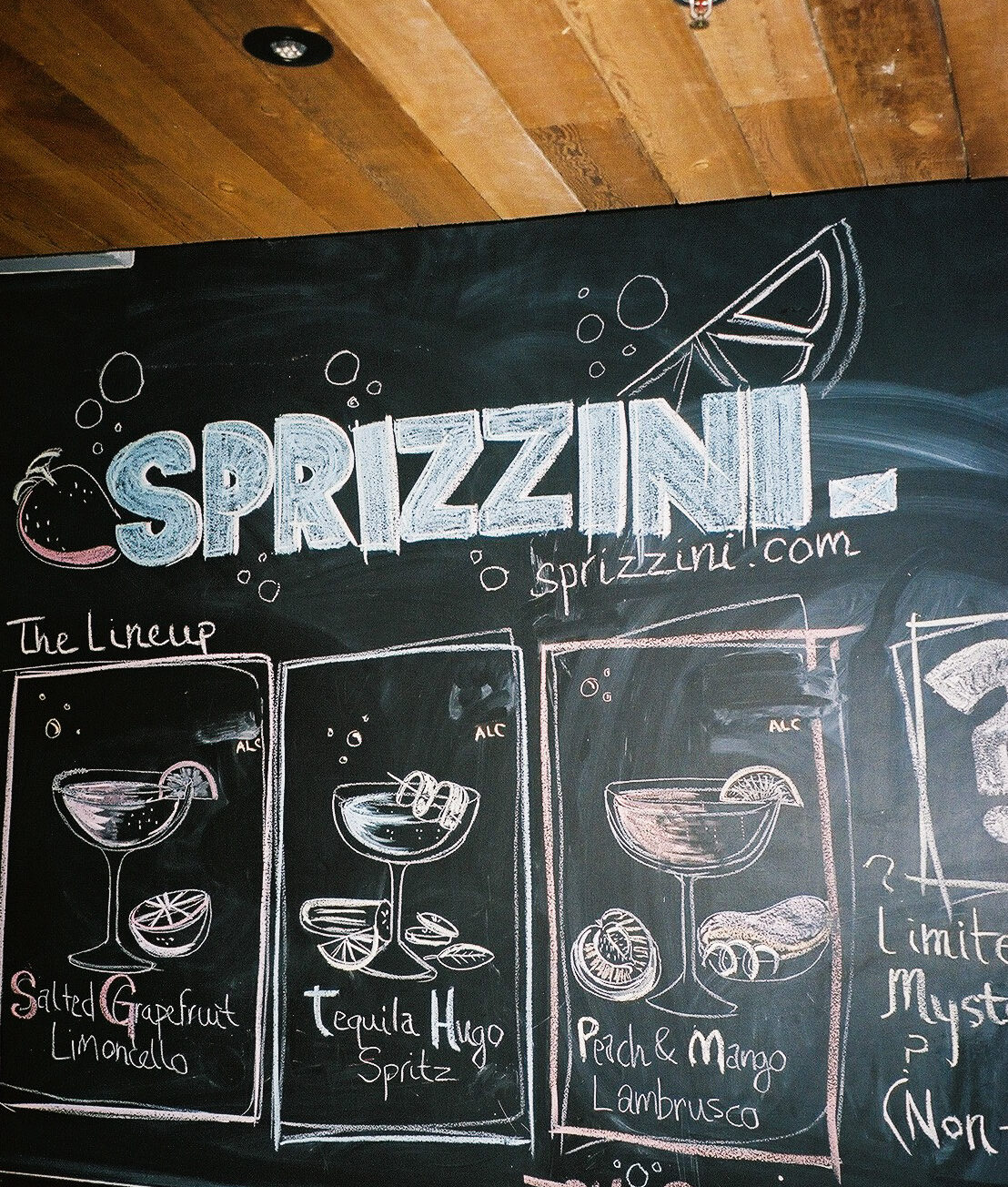 The chalkboard menu: Sprizzini lettering above three chalk-drawn drinks