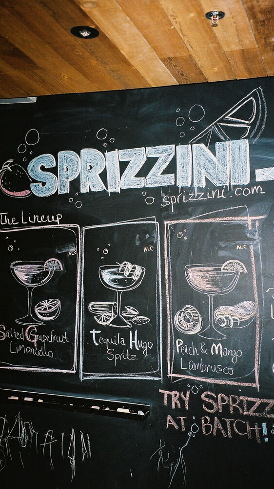 The chalkboard menu: Sprizzini lettering above three chalk-drawn drinks