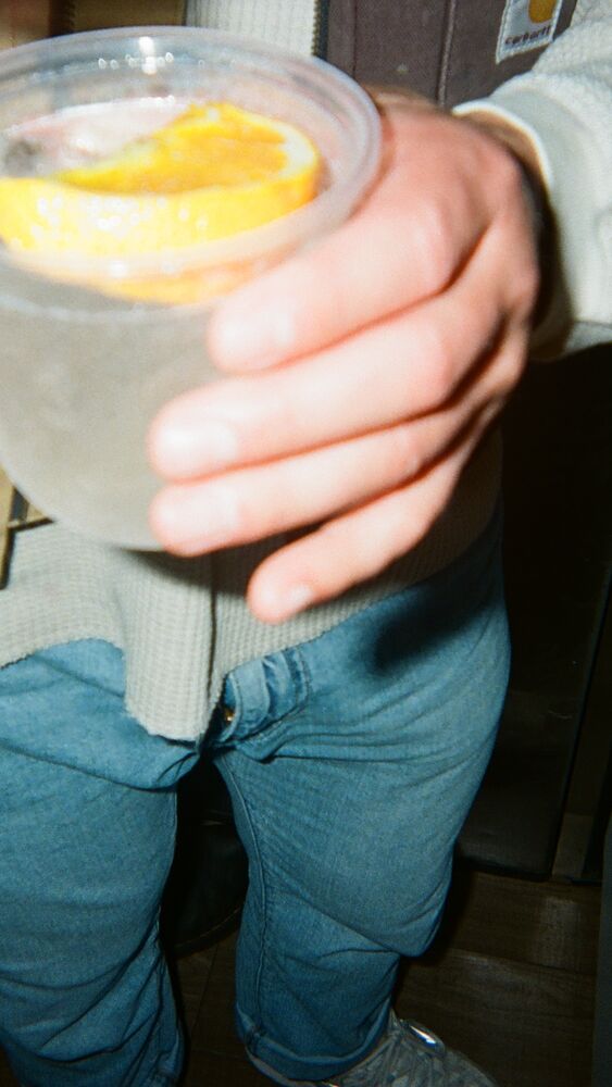 A spritz with an orange wheel held out toward the camera